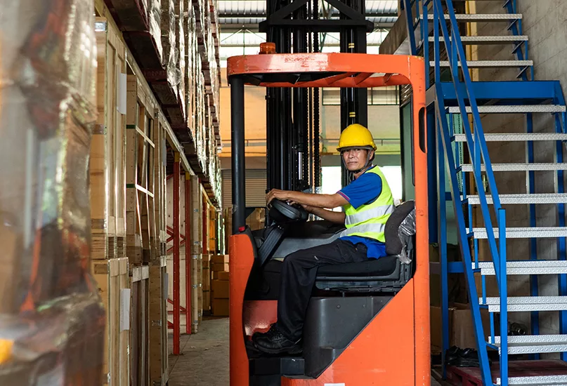 Man driving forklift truck in warehouse